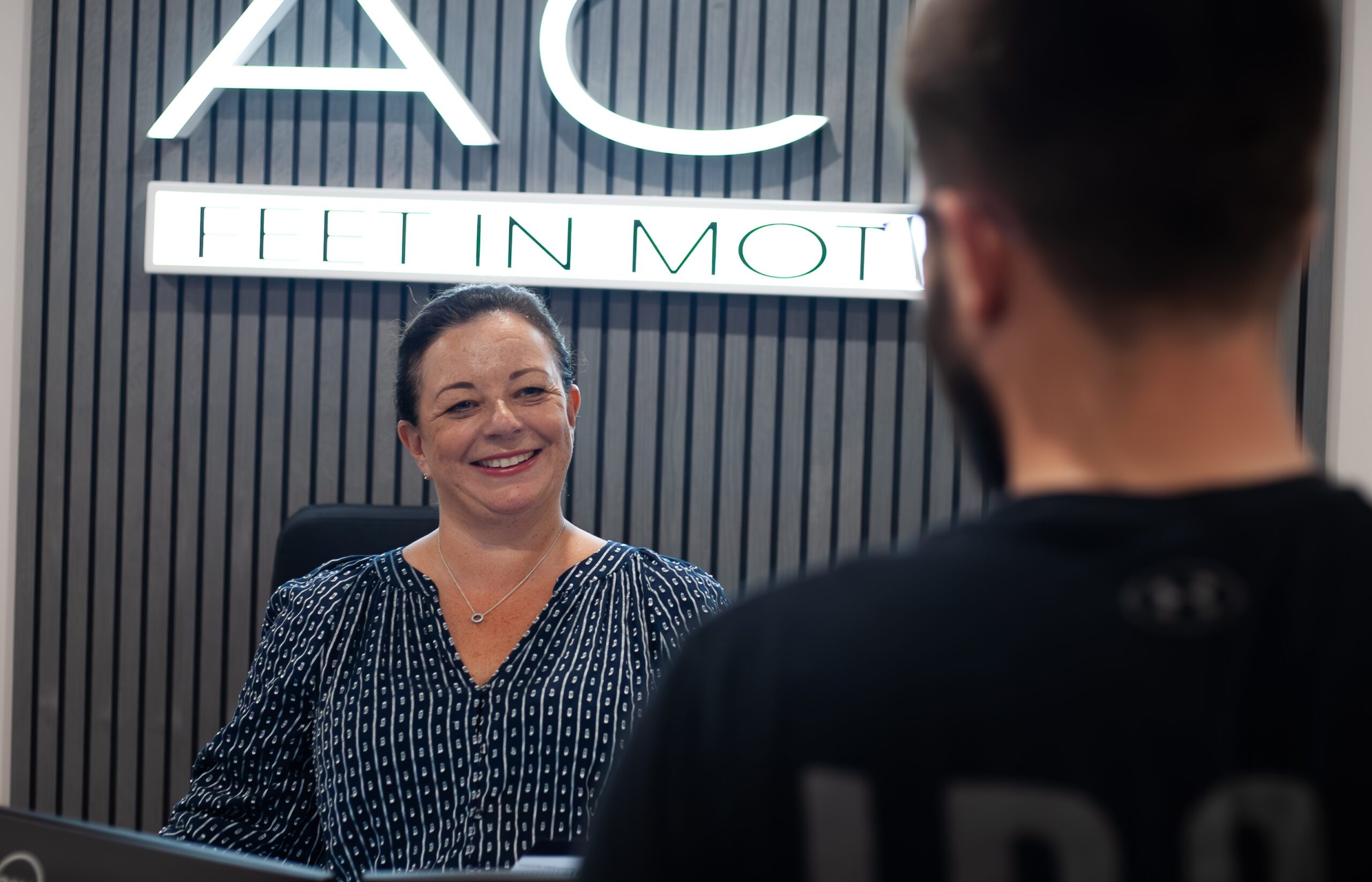 Customer Talking to a Friendly Receptionist at ACE Feet in Motion Cardiff